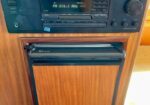 Vintage wood-paneled stereo cabinet housing a radio and cassette deck with a digital display.