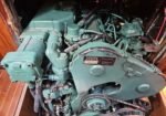 Volvo Penta marine engine in a wooden boat engine compartment, with green-painted components and belts, viewed from above