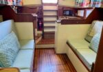 Boat cabin interior with two cushioned benches facing each other and a wooden floor.