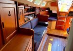 Cozy yacht cabin with blue upholstered seating, wooden cabinetry, and teak flooring.