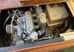 Marine diesel engine in a boat engine compartment, with hoses, belts, and metal pump components.