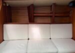 Wood-paneled cabin with white cushioned bench seating along the back wall, two-seat sections forming three cushions.