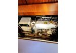 Marine diesel engine in a boat’s engine compartment, with hoses, belts, and a Komatsu-branded component.