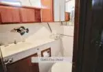 Guest/Day Head aboard a boat: wood cabinets, sink, mirror, and towel on a compact marine bathroom.