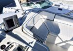 Close-up of a luxury boat cockpit with white cushioned seating, steering area, and a GPS/chartplotter on the console.