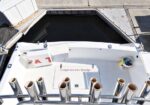 Top-down view of a white boat cockpit from the flybridge, showing multiple stainless rod holders along the edge and a hatch labeled 'Cockpit view from flybridge' (fishing setup).