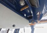 Inside a boat cabin underside with blue fiberglass, showing an overhead rod storage rack and a white panel/door nearby.