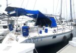 Sailboat named Azula docked at a marina with a blue canopy and fenders on the side of the boat.