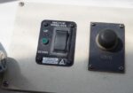 Close-up of a boat's control panel showing an anchor windlass switch (UP/DOWN) with a green reset button and a horn button labeled 'HORN'