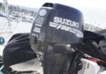 Outboard Suzuki 40 horsepower four-stroke marine engine on a boat at a marina.