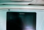 Close-up of a Raymarine navigation display mounted in a boat cockpit.