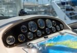 Boat cockpit dashboard with multiple round gauges and a map/chart on the console
