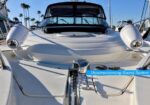 Close-up of a luxury yacht bow with chrome fixtures and two deck lights, a polished anchor winch, and a blue banner reading 'Uncompromising Sound System' across the foreground.
