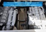 Twin Cummins 6BTA 5.9 diesel engines in a vessel's engine room, mounted side by side with a central metal deck walkway between them.