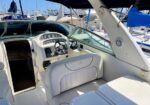 Boat cockpit on a marina with a steering wheel and instrument cluster visible at the helm
