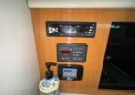 Wood-paneled wall with an electrical control panel and stereo unit, plus a fire extinguisher in front on the floor.