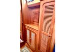 Wooden built-in cabinets with louvered doors in a narrow cabin or hallway area, giving a warm, nautical- or boat-like interior feel.