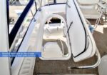 Open hatch showing a white molded staircase down to the lower deck on a boat, with the hatch door open.