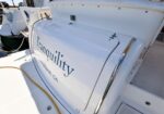 White yacht stern with the name Tranquility and '… Beach, CA' visible, docked at a marina