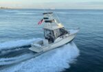 White motorboat speeding through open blue water, leaving a foamy wake with an American flag on the stern