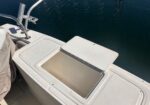 Open cooler on a boat deck with blue water in the background, lid propped up.