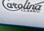 Close-up of a Catalina Classic logo on a white surface, with a dark curved underline and blue-green trim at the bottom.