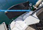 Molded staircase leading to the sundeck and storage locker on a white boat, with a covered item and blue water in the background.