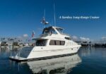 White luxury yacht moored in a calm marina with palm trees along the shore; overlay caption reads 'A Turnkey Long-Range Cruiser'.