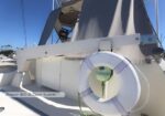 Life ring mounted on a Brower 800 lb davit system on a sailboat, with a marina and other boats in the background.