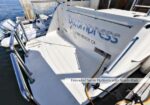 Boat at a dock featuring an extended swim platform with stainless rails; Long Beach, CA is visible on the stern label.