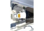 Electric anchor winch mounted on a boat deck with a thick chain feeding over the bow roller and anchor line nearby.