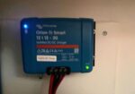 Blue Orion-Tr Smart solar inverter mounted on a wall with cables and LED indicators lit (blue/green).