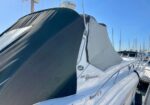 White Sundancer 340 motorboat with a dark cockpit cover moored at a marina
