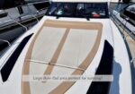 White motorboat bow with a large tan sun pad; overlay reads 'Large Bow Pad area perfect for sunning!'