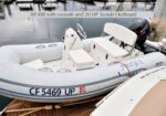 Inflatable AB RIB with console and a 20 HP Suzuki outboard docked at a marina; bow shows registration CF 5469 UP.