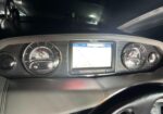 Car dashboard interior with two large round gauges on either side of a central touchscreen navigation display; steering wheel in the foreground.