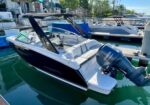Black and white motor boat docked at a marina, white seating, Yamaha outboard engine visible at stern .