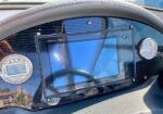 Garmin GPS navigation display (GPSMap 7607) mounted on a boat dashboard with a steering wheel reflection and round gauges nearby.