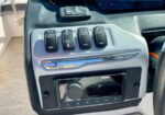 Boat helm panel with five rocker switches (Interior Lamps, Tower Up/Down, Dock Lights, etc.) and a Fusion stereo unit below.