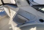 White boat cockpit with a recessed sink, stainless grab rails, and a sunlit cup holder area.
