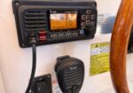 Close-up of ICOM VHF radio mounted on a boat console with a handheld mic below. (Informative)