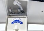 Boat water inlet with hot and cold valves and a curved white spout; hatch lid open showing a Scandvik logo.