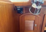 Wood-paneled boat interior with a wall-mounted black Espar heater beside a chrome light fixture.
