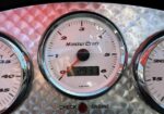 Close-up of a MasterCraft boat tachometer with a digital RPM display and check/engine lights below the gauge.