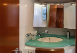 Teal vanity sink with an oval basin and chrome faucet in a small bathroom, mirrored cabinets above reflecting a towel area on a boat or RV bathroom.