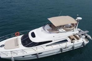 2007-cranchi-atlantique-50-power-9903934-20250808083544889-1 | Boat Universe A white luxury motor yacht with a beige canopy, seen from above on calm blue water.