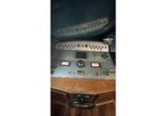 Cockpit of a vintage aircraft with a rows of switches and a central control yoke in the foreground.
