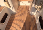 Teak boat deck in a cockpit area with coiled ropes on the right and hatches at the sides.