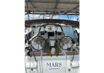 Sailing yacht Mars San Marino cockpit with dual steering wheels under a canopy, docked at a marina.