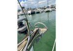 View from the bow of a boat in a marina, with moored yachts and city buildings in the background?cityscape